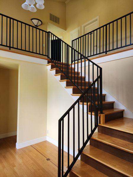 Modern staircase with wooden steps and black railings