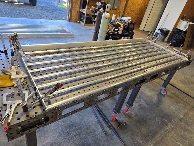 Welding table with clamped aluminum pieces, set up in a shop