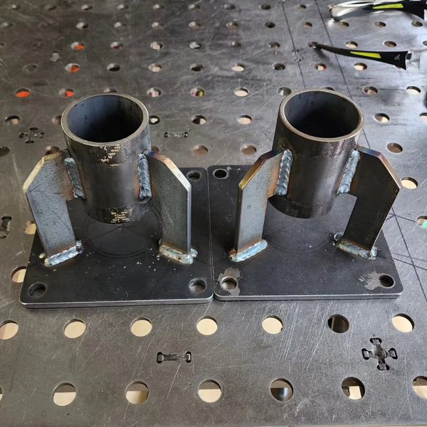 Two metal brackets with cylindrical mounts