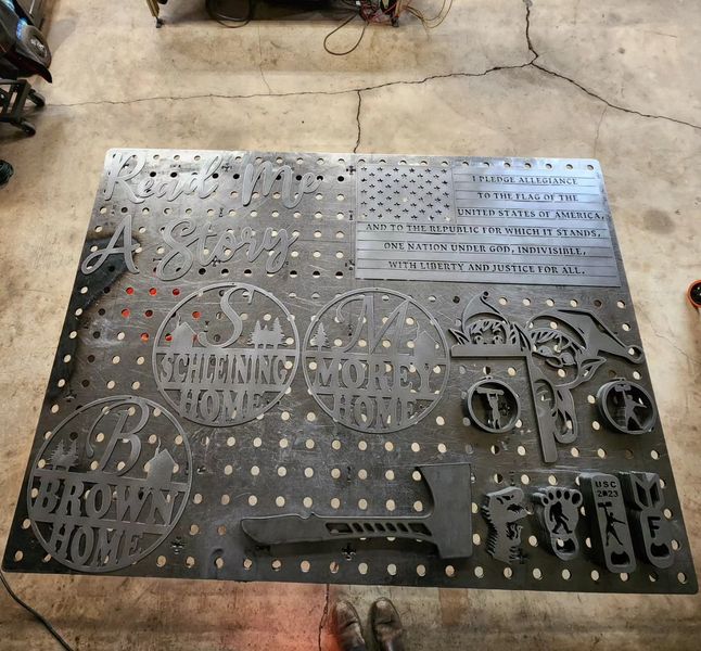 Metal art piece featuring cutouts of U.S. symbols, names, and patriotic text