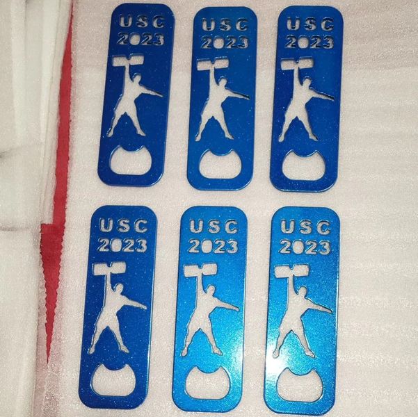 Six blue bottle openers displaying "USC 2023" and a silhouette of a weightlifter