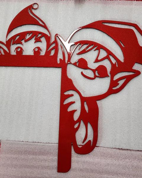 Red metal decoration featuring two playful elf characters,